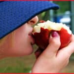 Girl in Hat Eating an Apple