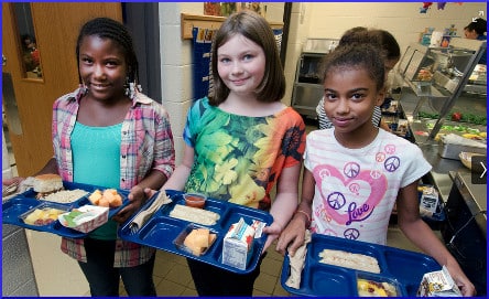 children holding school lunch trays