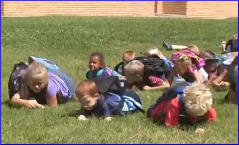 schoolchildren lying on grass
