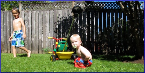 [two small boys playing in a backyard]