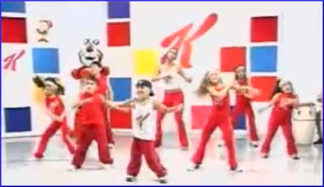 [children dancing in front of Kellogg logo]