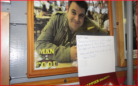 [photo of Adam Richman on a restaurant wall]