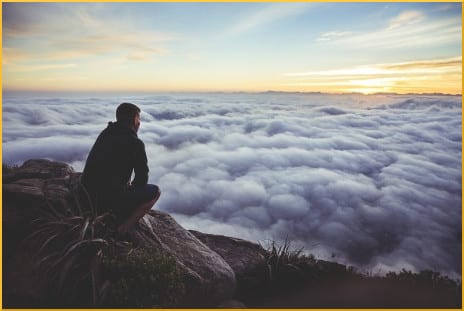 man-on-rock-with-clouds